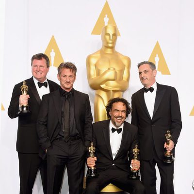 Alejandro González Iñárritu poses next to his three Oscars and Sean Penn